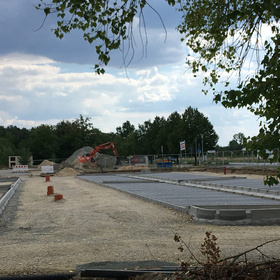 Baustelle mit Bagger und vorbereiteten Flächen für den Unterbau