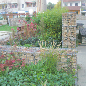 Mit Steinen gefüllte Drahtkörbe als Gestaltungselement in einer Gartenanlage