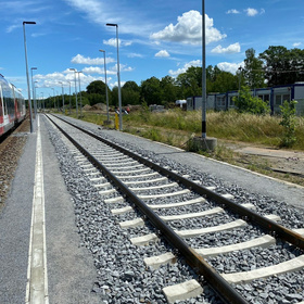 Bahngleis mit Schotterbett an einem Bahnsteig
