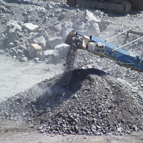 Maschine beim Zerkleinern von Gestein mit herabfallendem Material