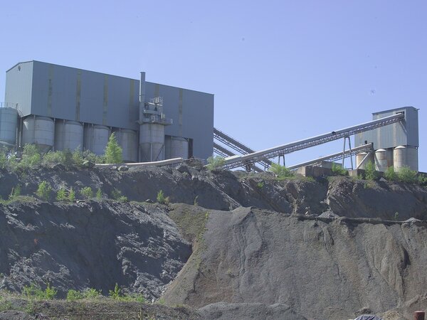 Aufbereitungsanlage mit Silos und Förderband auf einer Felskante