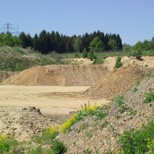 Offene Rohstoffabbaufläche mit Sand- und Erdhalden