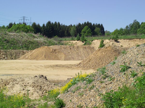 Offene Rohstoffabbaufläche mit Sand- und Erdhalden