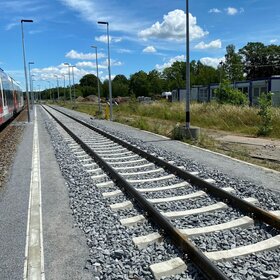 Bahngleis mit Schotterbett an einem Bahnsteig